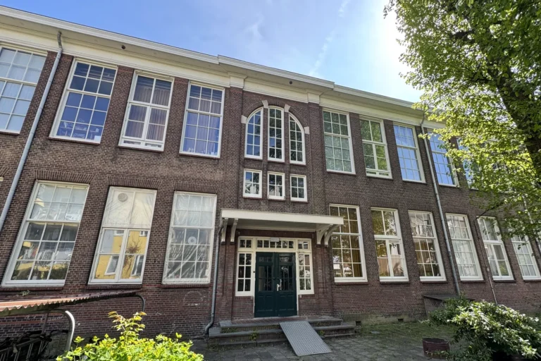 Voormalig schoolgebouw in Rotterdam met atelierruimtes, gezien vanaf het binnenterrein