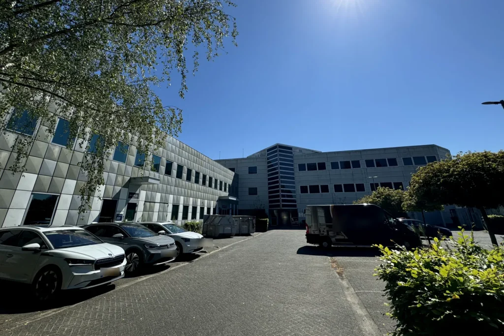 Kantoorpand in Hilversum met geprofileerde gevelpanelen, gezien vanaf het parkeerterrein